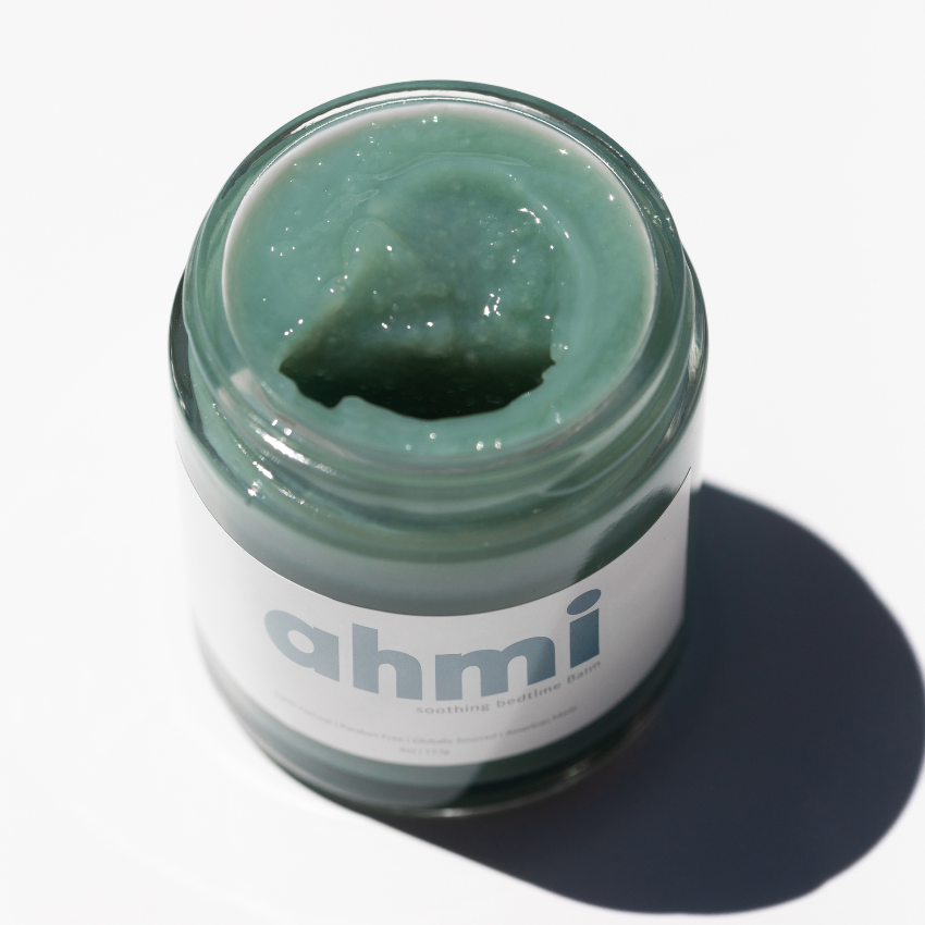 Close up of Ahmi balm texture with lid off on a white background.